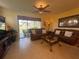 Comfortable living room with leather sofas, tile flooring, and a sliding door to the lanai at 2334 Felicity Pl, North Port, FL 34289