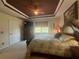 Main bedroom features a tray ceiling, fan, and large window at 2334 Felicity Pl, North Port, FL 34289