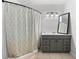 Clean bathroom features a shower with decorative curtain, vanity with grey cabinets, and modern lighting at 2361 Rose St, Sarasota, FL 34239