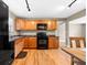 Well-lit kitchen featuring stainless steel appliances, warm wood cabinets, and black countertops at 2361 Rose St, Sarasota, FL 34239