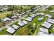 Aerial view of a residential neighborhood with mature trees, golf course, community pool, and tennis court at 3140 Village Green Dr # 1119, Sarasota, FL 34239