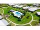 Aerial view of a landscaped area with a pool and shade structure in a residential community at 3140 Village Green Dr # 1119, Sarasota, FL 34239
