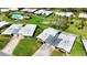 Aerial view showcases lush green landscaping, community pool, tennis courts, and residential buildings at 3140 Village Green Dr # 1119, Sarasota, FL 34239