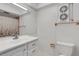 Clean bathroom with a toilet, vanity sink, and shower featuring patterned curtain for privacy at 3140 Village Green Dr # 1119, Sarasota, FL 34239