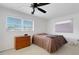 Cozy bedroom with ceiling fan, two windows for ample natural light, and wooden dresser at 3140 Village Green Dr # 1119, Sarasota, FL 34239