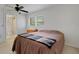Cozy bedroom featuring a ceiling fan, window with blinds, and en-suite bathroom at 3140 Village Green Dr # 1119, Sarasota, FL 34239