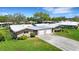 Well-manicured lawns surround paired single-story homes with attached garages and clean rooflines at 3140 Village Green Dr # 1119, Sarasota, FL 34239