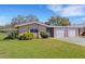 Inviting single-story home with a lush green lawn, tidy landscaping, and attached single-car garage at 3140 Village Green Dr # 1119, Sarasota, FL 34239