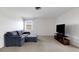 Cozy living room featuring a comfortable sofa, neutral carpet, and a TV on a console at 3140 Village Green Dr # 1119, Sarasota, FL 34239