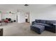 Open-concept living room with neutral carpet, ceiling fans, and view into office and kitchen at 3140 Village Green Dr # 1119, Sarasota, FL 34239