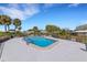 Community pool surrounded by lounge chairs and manicured landscaping at 3140 Village Green Dr # 1119, Sarasota, FL 34239