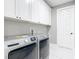 Bright laundry room featuring modern washer and dryer, white cabinets, and marble flooring at 3367 Tucson Rd, North Port, FL 34286