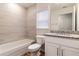 Bright bathroom boasts tub, tiled walls, granite countertop, and wood-look flooring at 3438 Alwood St, North Port, FL 34291