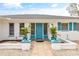Front entrance featuring decorative plants, a bright blue door, and a brick path at 3611 22Nd W Ave, Bradenton, FL 34205