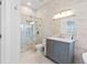 Elegant bathroom with glass shower, marble walls, and a gray vanity cabinet at 3707 5Th Ne Ave, Bradenton, FL 34208