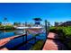Boat lift on canal with boat, adjacent to a wooden dock and lush greenery, showcasing waterfront living at 3707 5Th Ne Ave, Bradenton, FL 34208