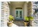 Elegant entryway features double doors, stone columns, and potted plants, creating a grand welcoming ambiance at 3707 5Th Ne Ave, Bradenton, FL 34208