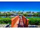 Charming wooden bridge leading to a canal with boats docked at waterfront homes under a clear blue sky at 3707 5Th Ne Ave, Bradenton, FL 34208