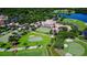 Aerial view of the golf course and clubhouse featuring landscaped grounds, greens, and trees at 402 Walls Way, Osprey, FL 34229
