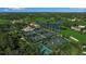 Aerial view showcases tennis courts and golf course with beautiful landscaping and surrounding lush greenery at 402 Walls Way, Osprey, FL 34229