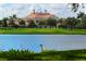 Back view of yellow house with red tile roof and beautiful landscaping on the water at 402 Walls Way, Osprey, FL 34229