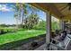 Covered patio overlooking lush backyard, mature trees, and tranquil lake view at 402 Walls Way, Osprey, FL 34229