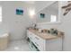 Bright bathroom featuring double vanity, granite countertops, white cabinetry, and tile floors at 402 Walls Way, Osprey, FL 34229