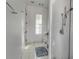 Bright bathroom featuring white tile flooring, a window with shutters, and a glass-enclosed shower at 402 Walls Way, Osprey, FL 34229