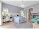 Well-lit bedroom showcasing a chandelier, hardwood floors, and soft blue walls with white trim at 402 Walls Way, Osprey, FL 34229