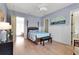 A tranquil bedroom with four poster bed, paneled walls, and wood floors at 402 Walls Way, Osprey, FL 34229
