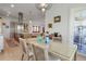 Dining room with modern chandelier, glass table, and seating for four and open view to kitchen and living spaces at 402 Walls Way, Osprey, FL 34229