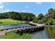 Scenic golf course bridge across a pond, surrounded by lush tropical foliage and a pristine green at 402 Walls Way, Osprey, FL 34229