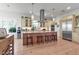 Bright kitchen with stainless steel appliances, island with seating, and custom cabinetry at 402 Walls Way, Osprey, FL 34229