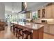 Bright kitchen featuring an island with seating, and tan cabinetry at 402 Walls Way, Osprey, FL 34229