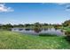 Picturesque view of a serene pond surrounded by lush landscaping and greenery at 402 Walls Way, Osprey, FL 34229