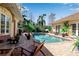 A private backyard oasis featuring a sparkling pool, lush landscaping, and comfortable seating areas at 402 Walls Way, Osprey, FL 34229