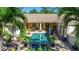A tranquil backyard featuring a sparkling pool and spa, complemented by lush tropical landscaping at 402 Walls Way, Osprey, FL 34229