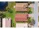 A high-angle perspective of neighborhood homes showcasing red roofs and neat lawns beside calm lake, near paved road at 4134 63Rd E Ter, Sarasota, FL 34243