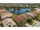 An aerial view of a residential community surrounding a tranquil lake, showcasing lush greenery and well-maintained properties at 4134 63Rd E Ter, Sarasota, FL 34243