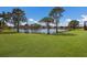 Grassy backyard with mature trees overlooks the serene lake at 4134 63Rd E Ter, Sarasota, FL 34243