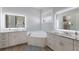 Bathroom with soaking tub, dual vanities, modern lighting, and wood-look floors at 4134 63Rd E Ter, Sarasota, FL 34243