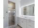 Bathroom with shower, white vanity, and a large, lighted mirror at 4134 63Rd E Ter, Sarasota, FL 34243