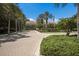 Community entrance with stone gate, mature trees, a paved entry road, and an American flag at 4134 63Rd E Ter, Sarasota, FL 34243