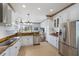 Modern kitchen featuring stainless steel appliances, white cabinetry, granite countertops, and an open view into the living area at 4134 63Rd E Ter, Sarasota, FL 34243