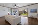 Bright living room features neutral walls, a ceiling fan, wood flooring, and glass sliding doors opening to the back patio at 4134 63Rd E Ter, Sarasota, FL 34243