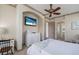 Main bedroom featuring a ceiling fan, wall-mounted TV, and doorway to a bathroom at 4134 63Rd E Ter, Sarasota, FL 34243