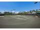 Community tennis courts surrounded by greenery and mature trees on a clear day at 4134 63Rd E Ter, Sarasota, FL 34243