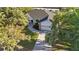 Aerial view of the home featuring mature landscaping and a paver driveway leading to the two car garage at 4444 Robin Hood Trl W, Sarasota, FL 34232