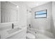 Modern bathroom featuring a tub with glass door, shower head, single sink with vanity and a window at 4444 Robin Hood Trl W, Sarasota, FL 34232