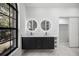 Bathroom features a double vanity with illuminated mirrors, and a marble tile floor at 4444 Robin Hood Trl W, Sarasota, FL 34232